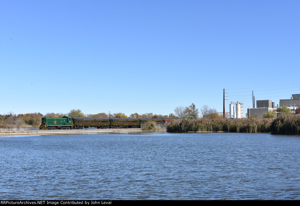 The 304 and its train sits on the bridge over the lake next to the Mannington Mills factory building 